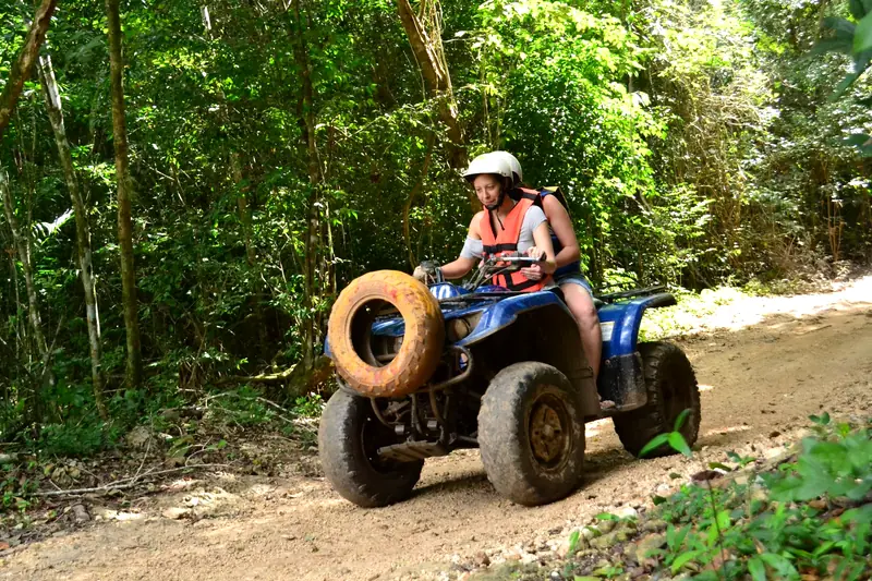 Visitante en cuatrimoto por un camino de la selva