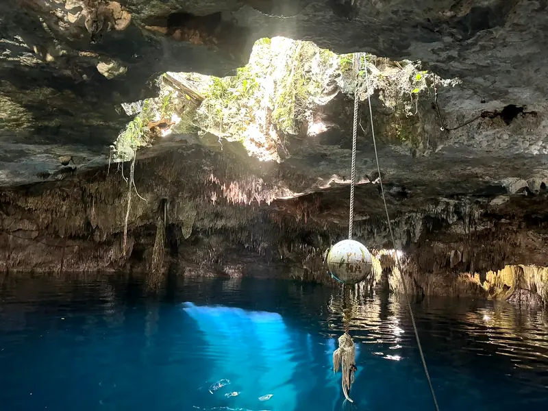 Entrada de luz natural sobre el agua azul de la cueva Kin-Ha