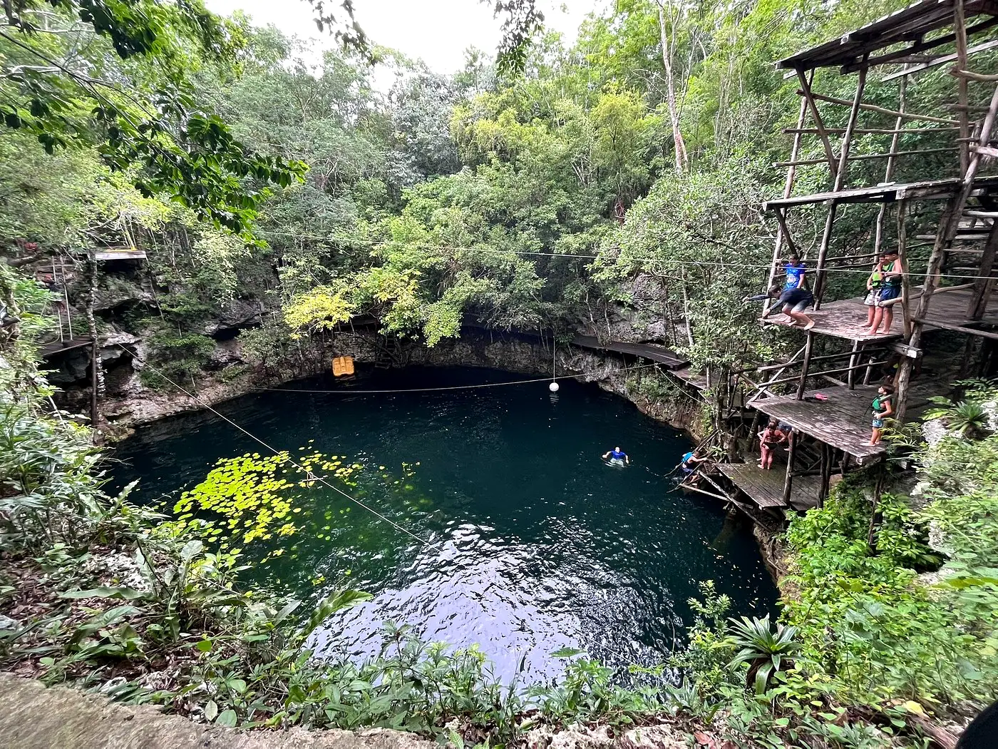 Cenote Blanca Flor abierto al cielo, con plataformas de salto y selva alrededor
