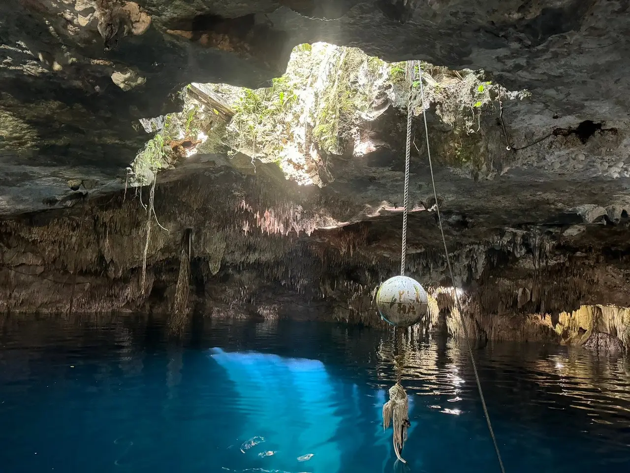 Natural light over the turquoise water of Kin-Ha cenote